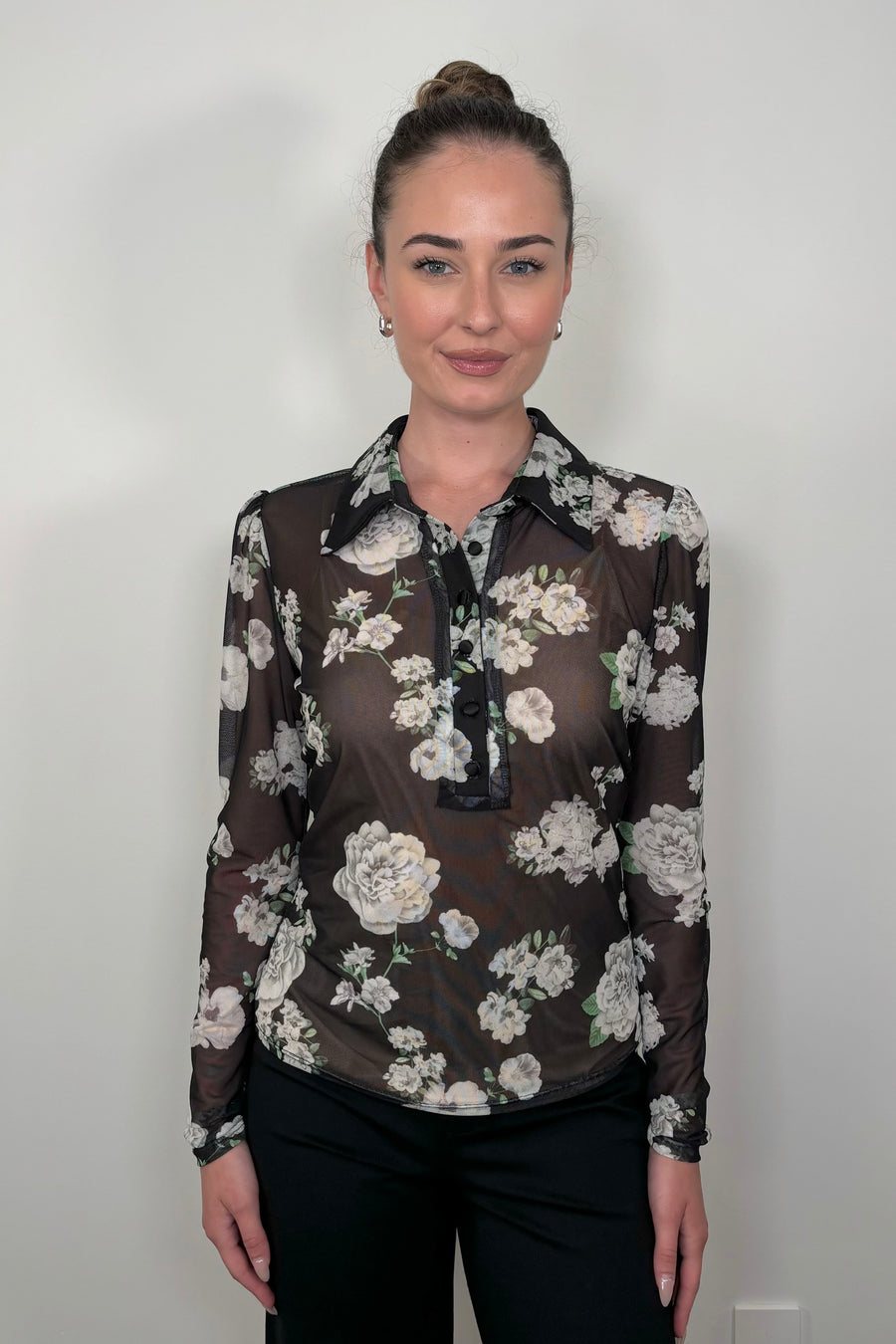 Woman wearing a black mesh floral shirt