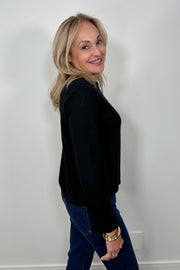 Side view of woman wearing a cashmere long sleeve white shirt