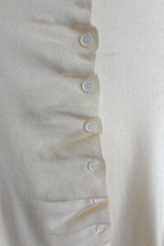 Front zoom in view of a rouched in the buttons cream long sleeve knitted top