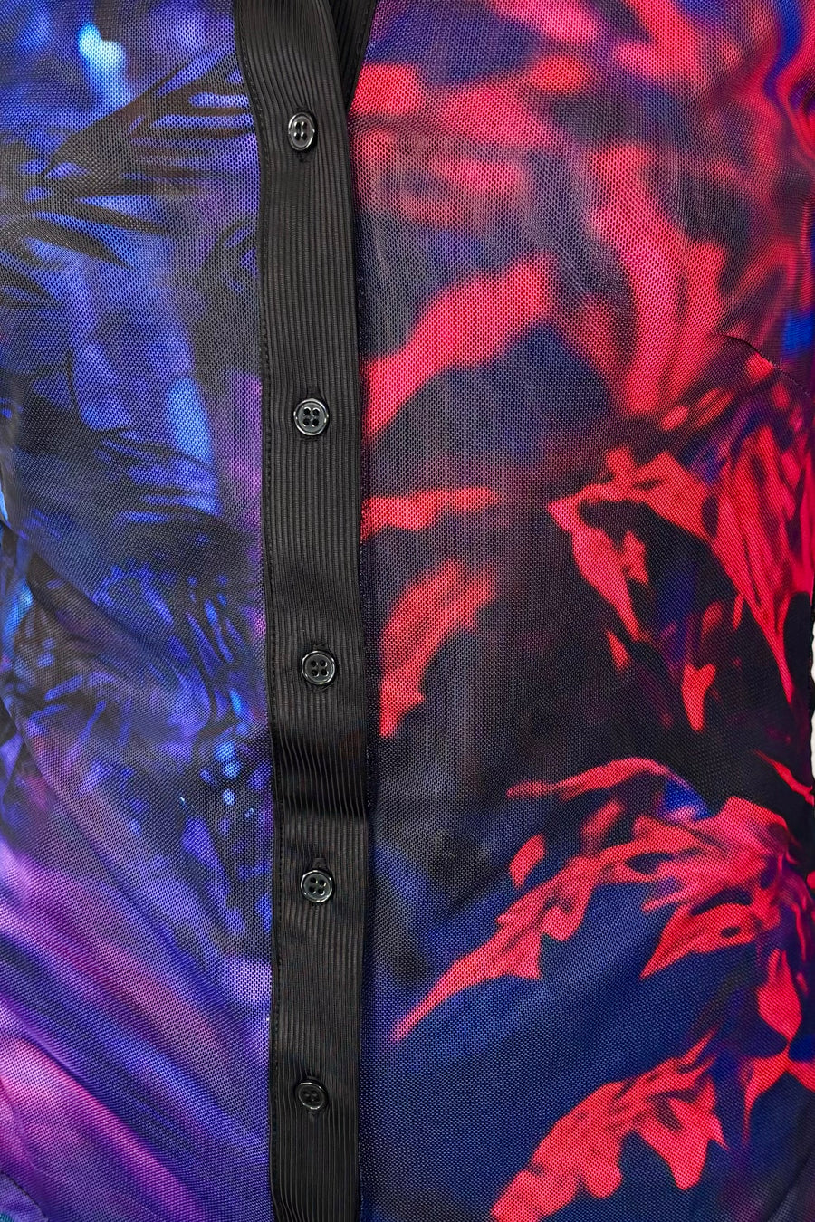 Close-up of the torso of a woman wearing a blue and red long sleeve mesh shirt