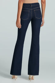 Back facing woman wearing a mid-rise flared dark wash jean
