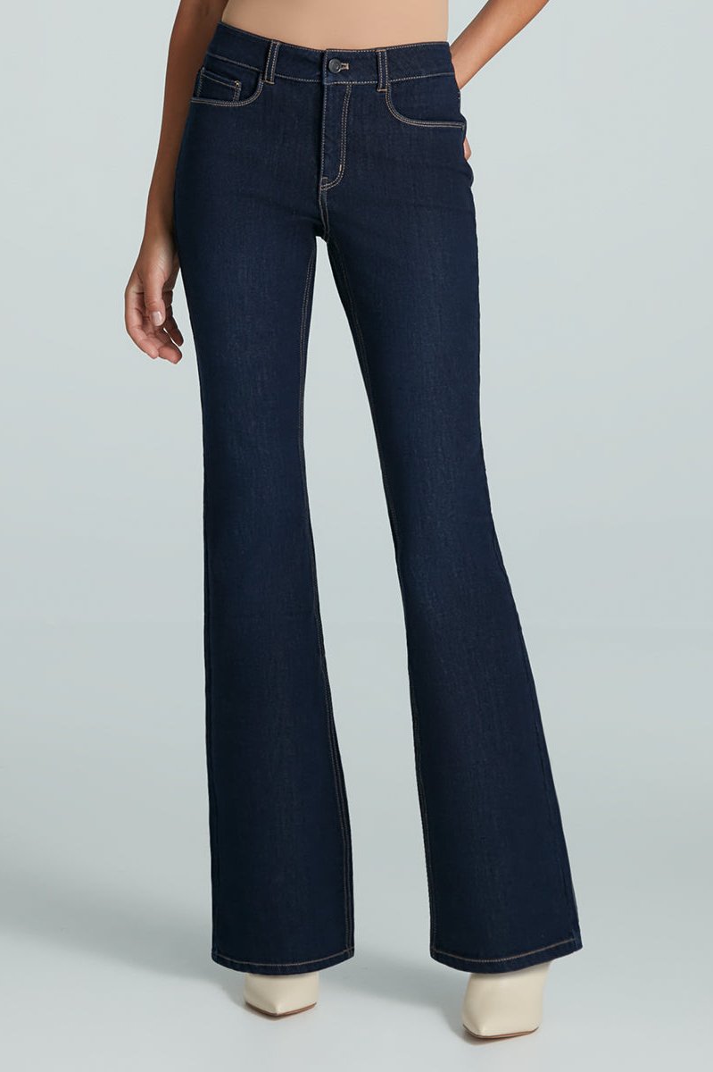 Front facing woman wearing a mid-rise flared dark wash jean