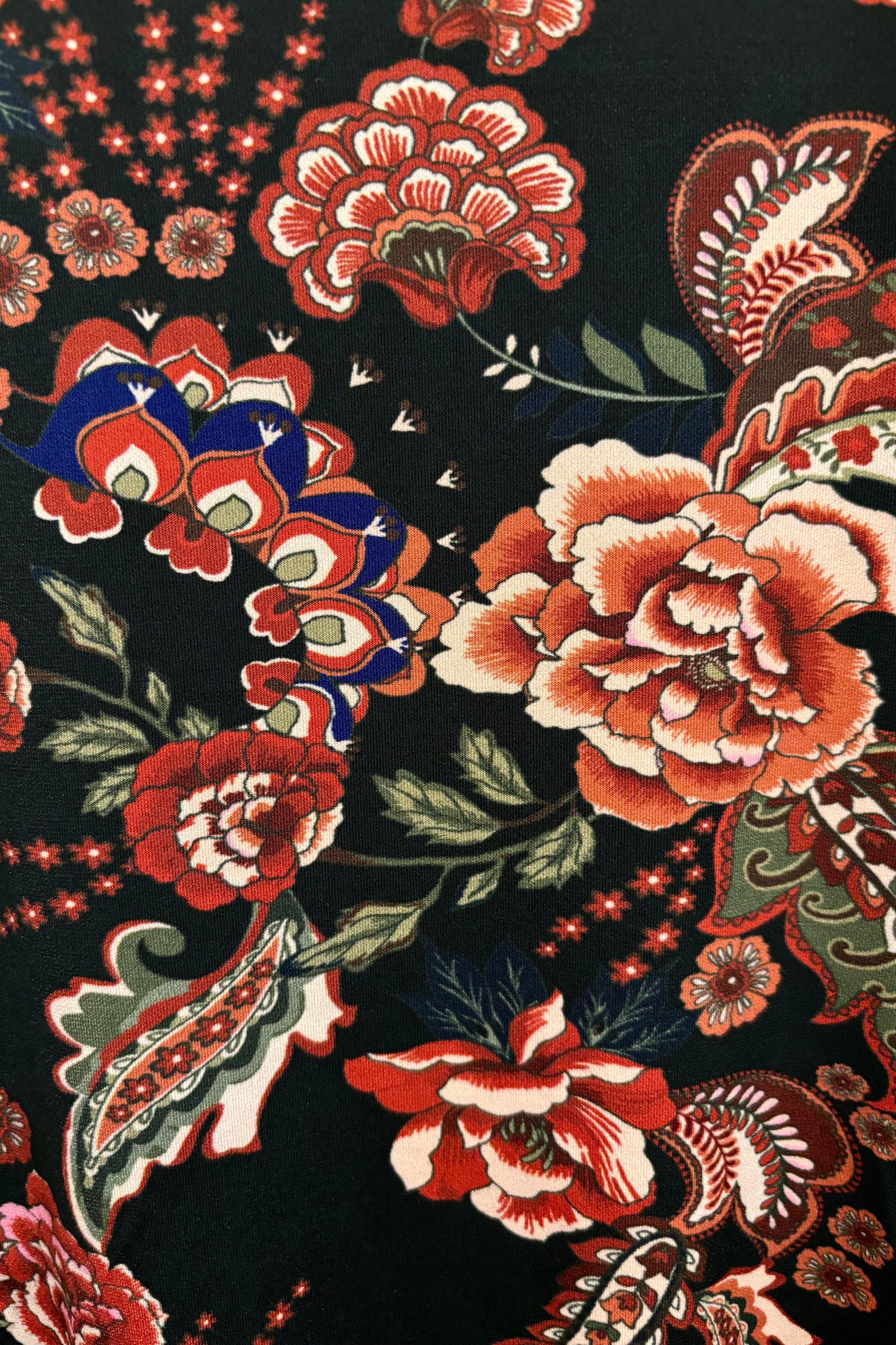 Close up view of a midi dress with floral and paisley pattern