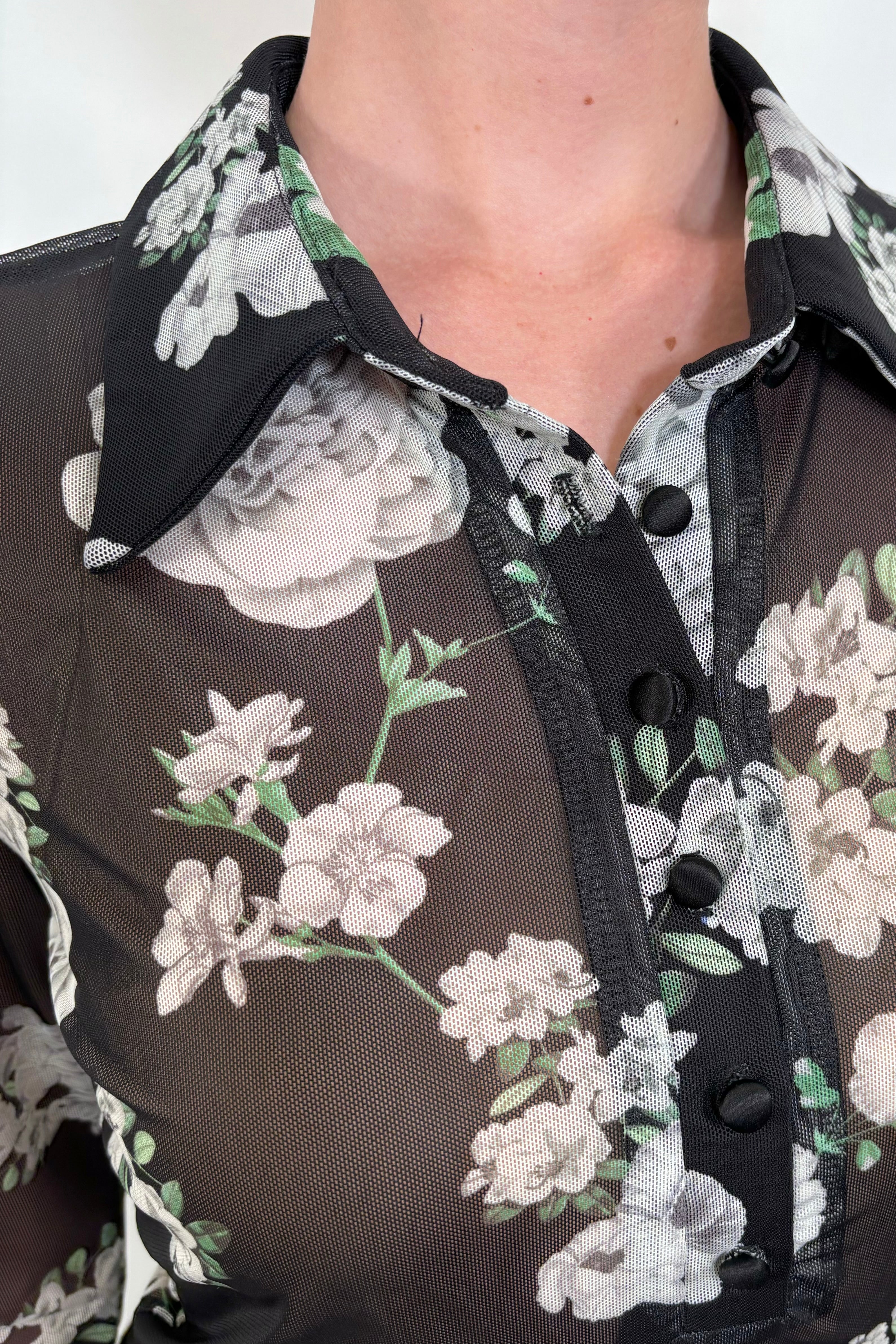 Close-up view of a black mesh floral shirt