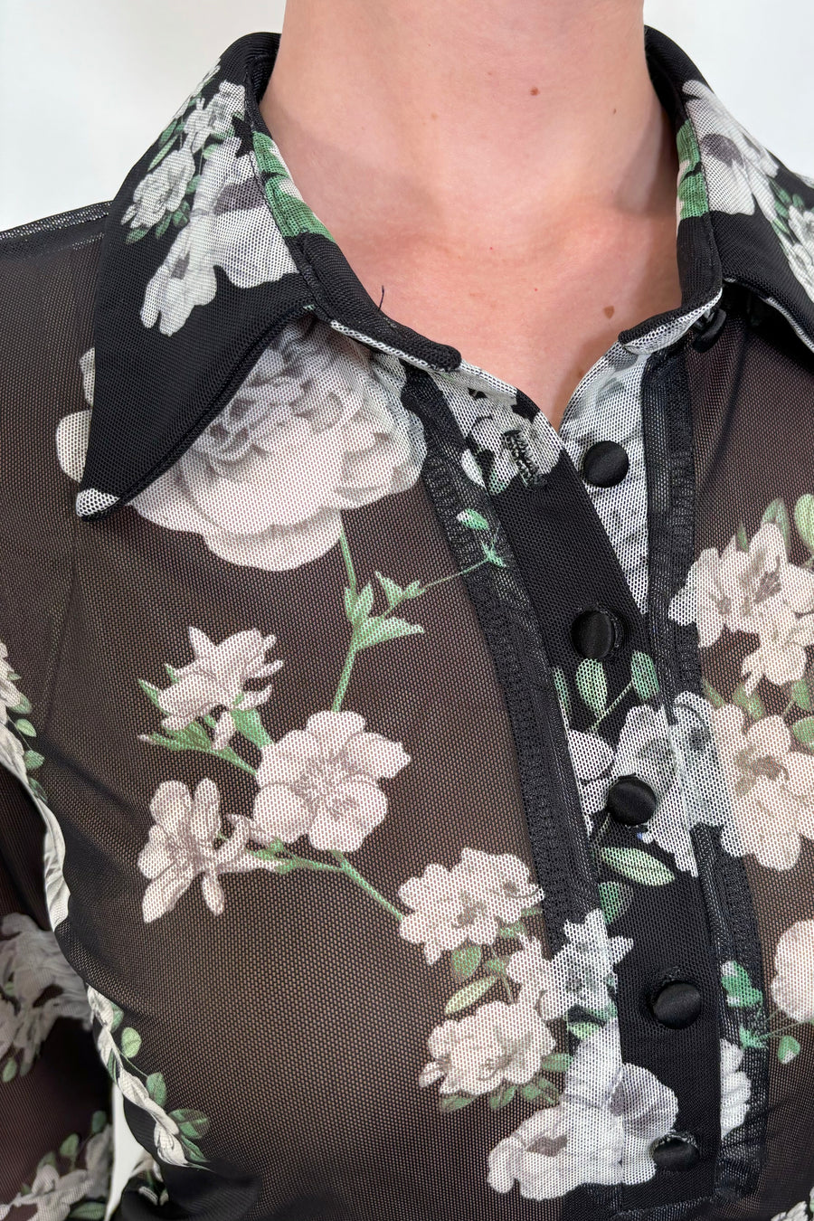 Close-up view of a black mesh floral shirt