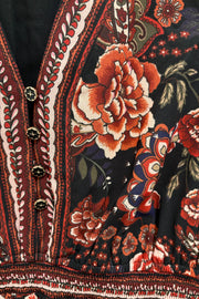 Close-up of a short long sleeve dress with floral and paisley patterns.