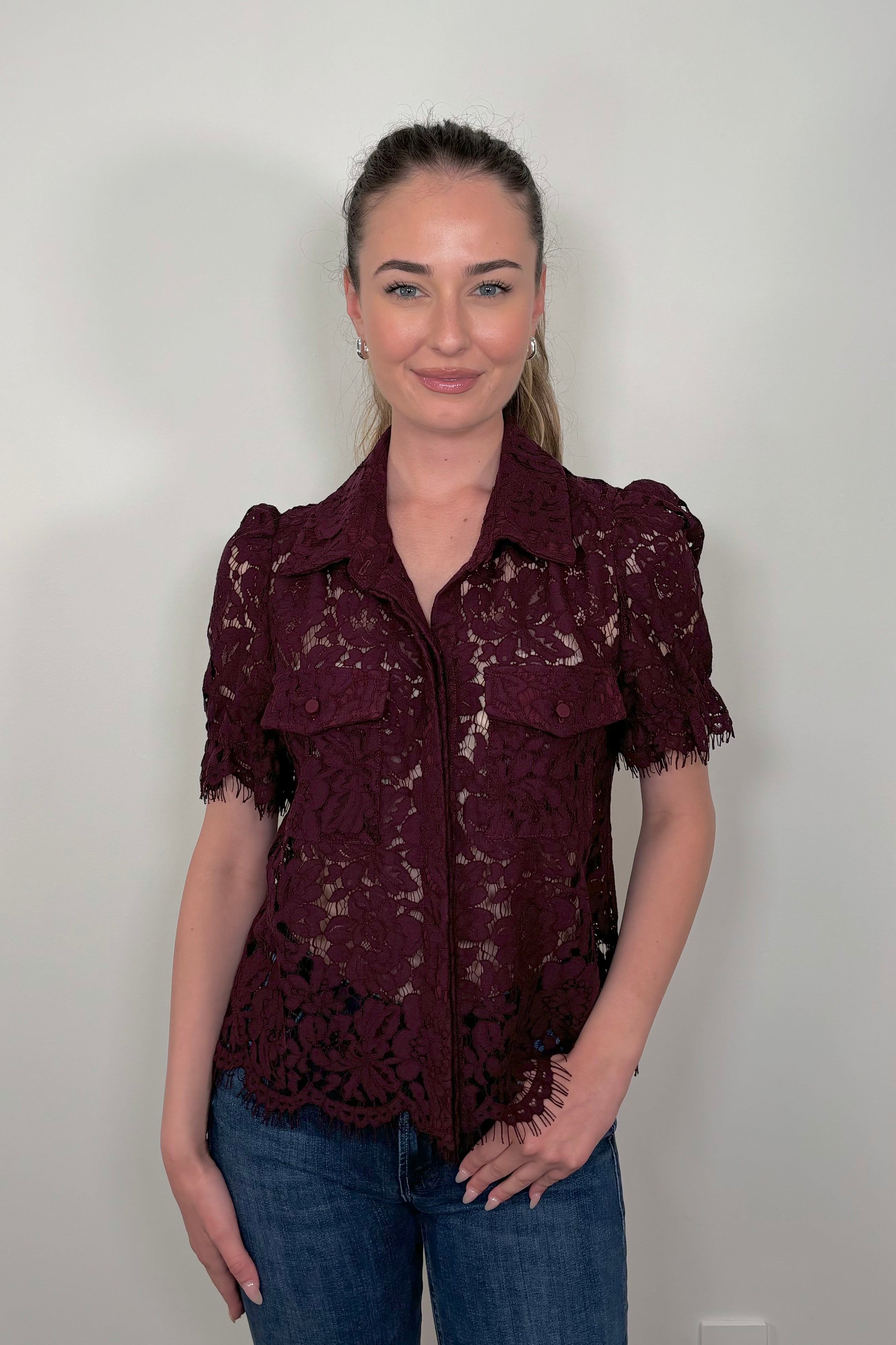 Font view of woman wearing a button down short sleeve lace blouse