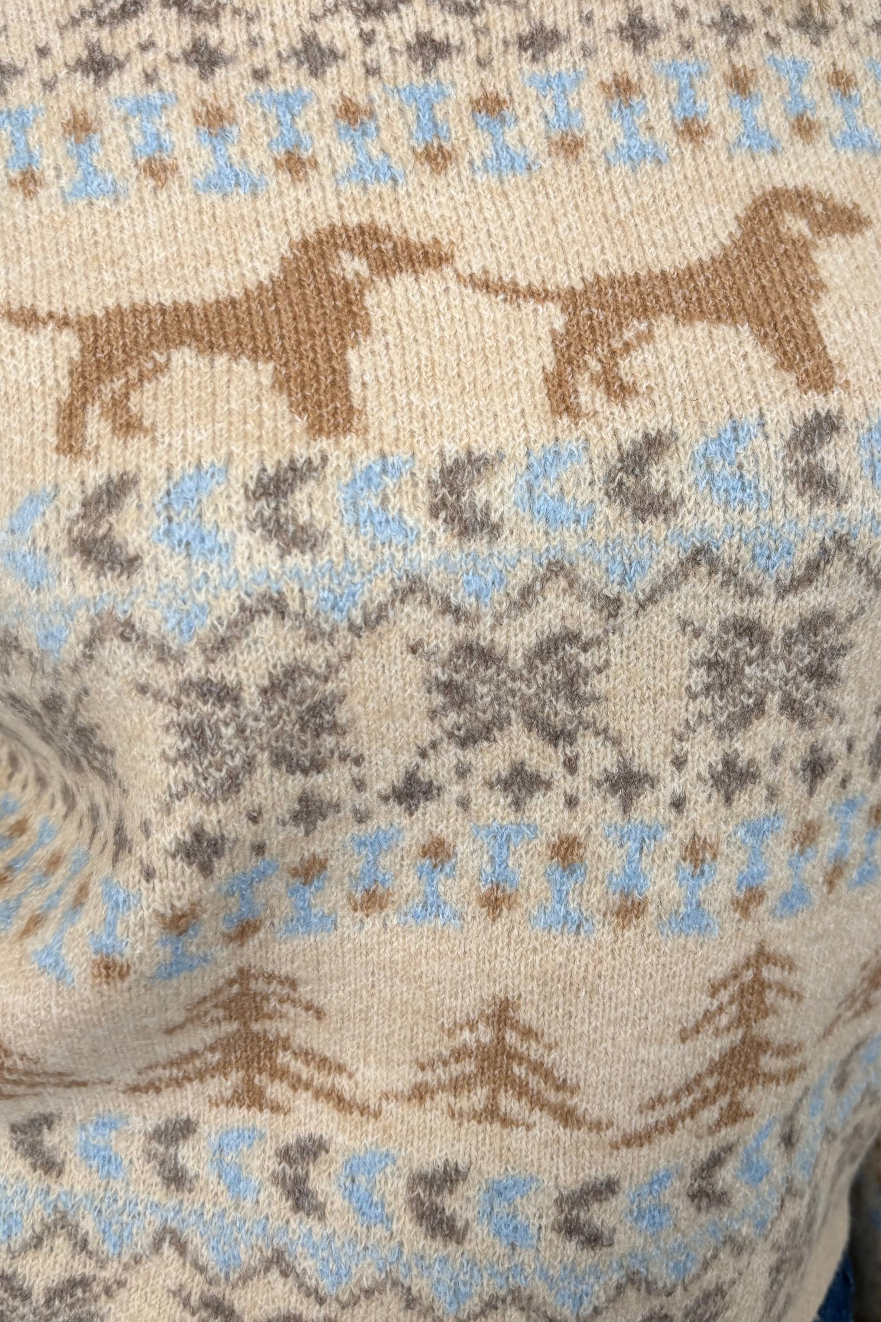 Close-up of a fabric with a pattern of dogs and floral elements.
