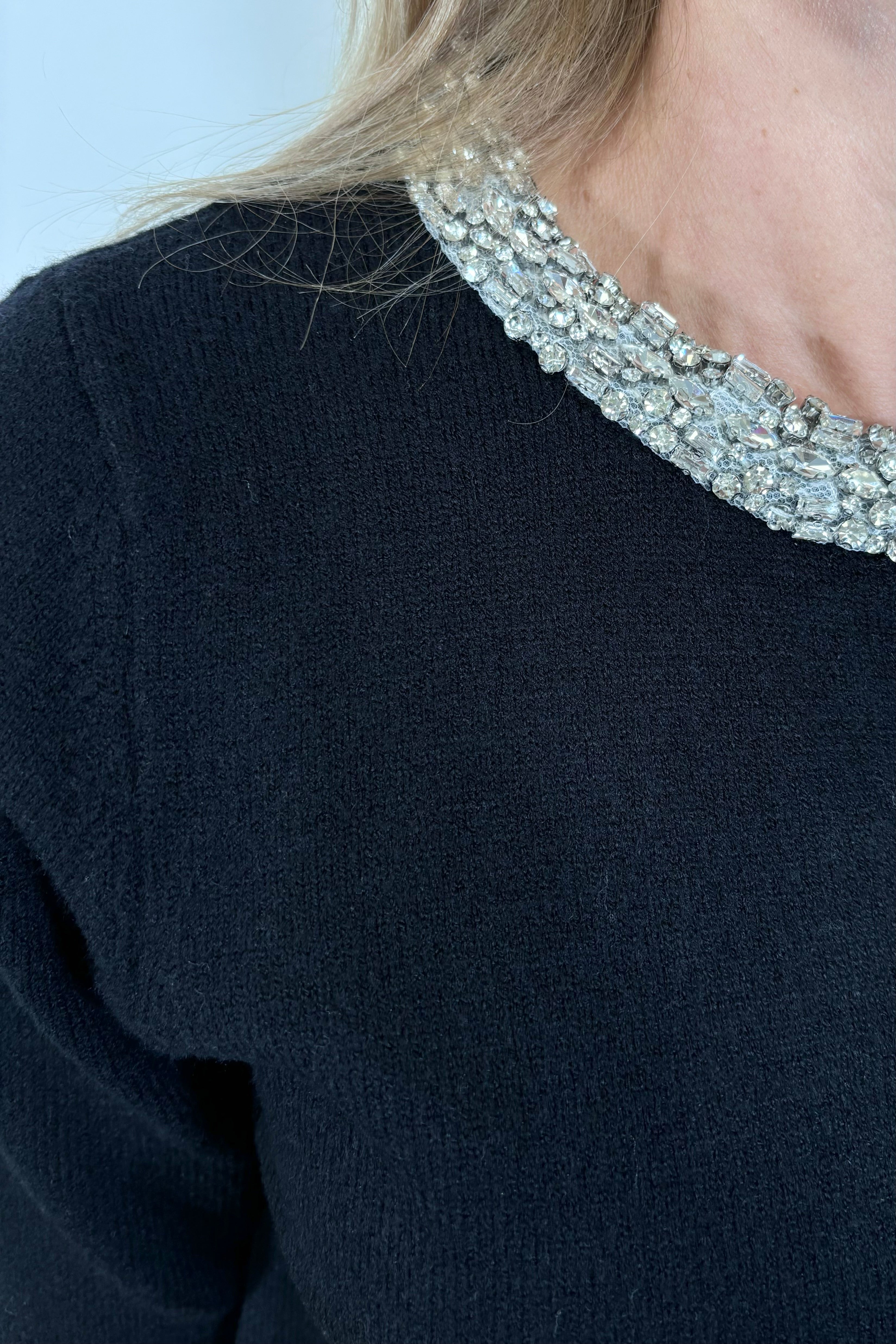 close up of a half sleeve black cardigan with crystal detailing