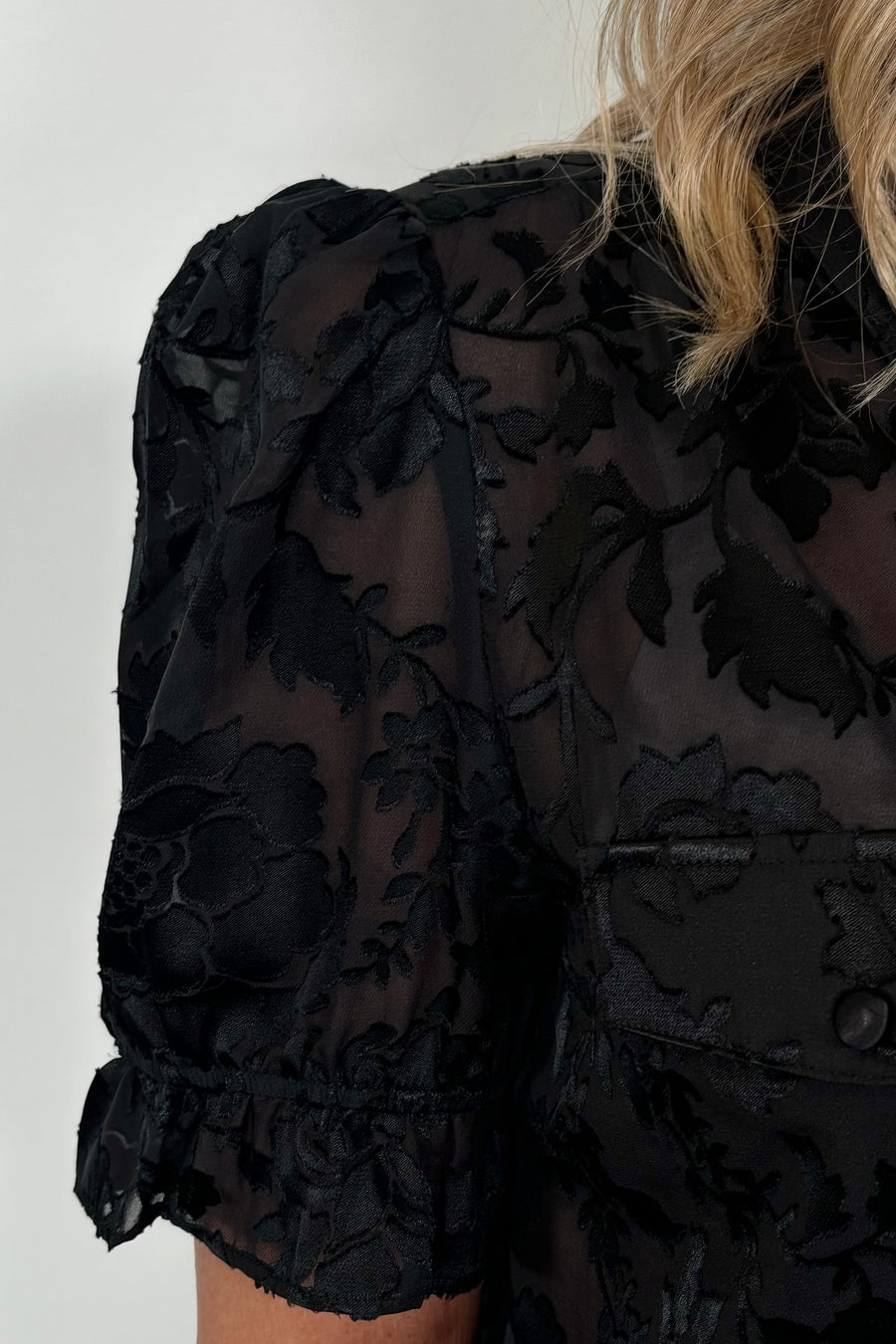 Close-up of the shoulder of a black burnout short sleeve shirt