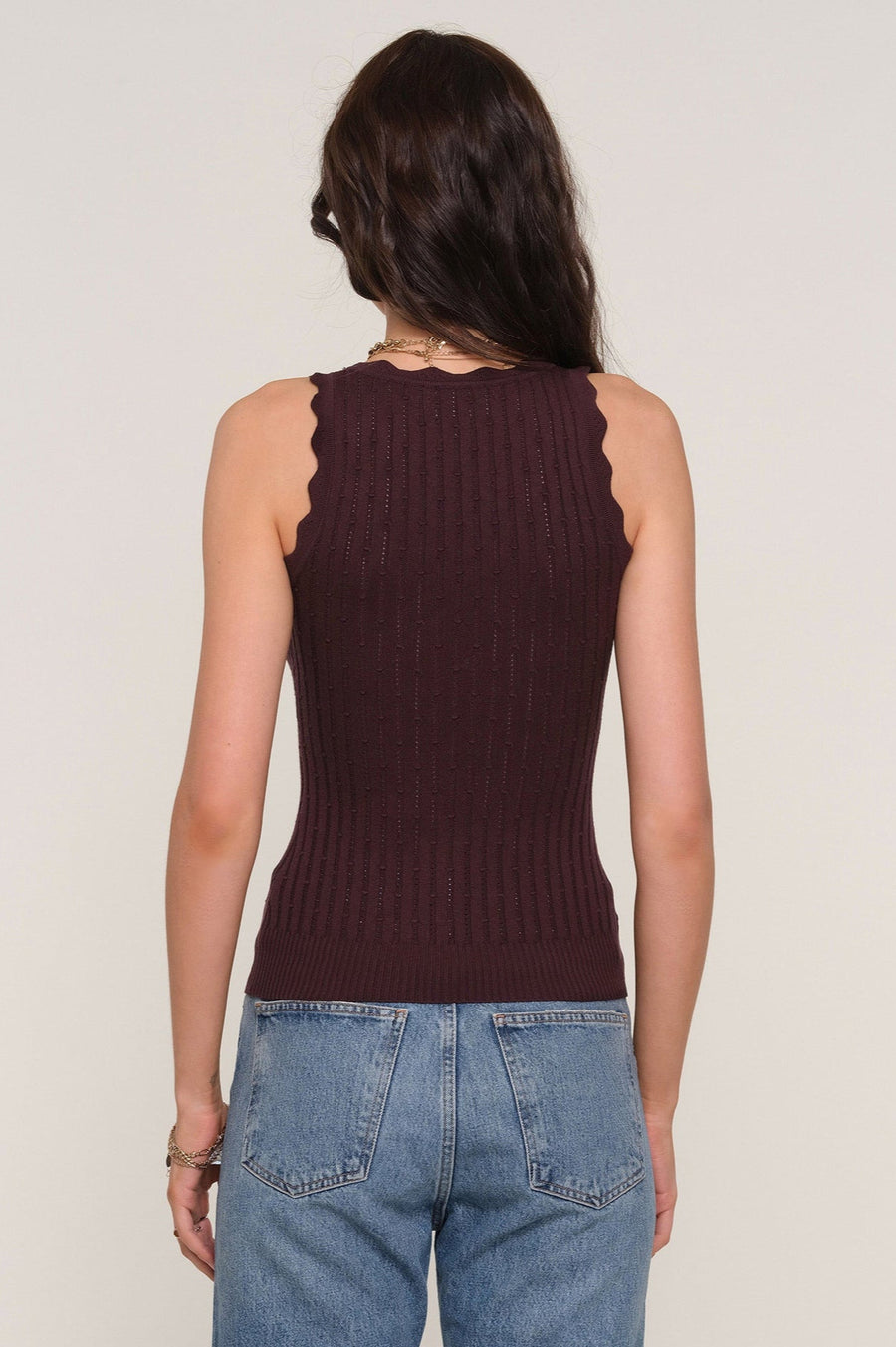 Back facing woman wearing a brown squared neck knitted tank top.