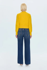 Person wearing a yellow sweater and blue jeans on a white background