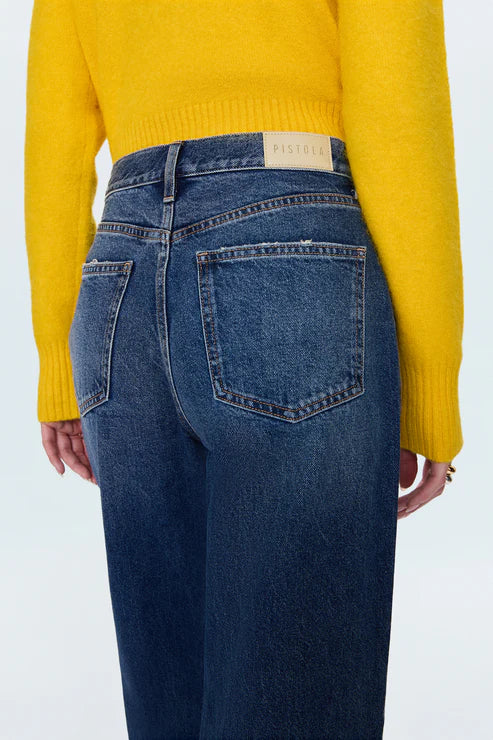 Person wearing blue jeans and a yellow sweater on a white background