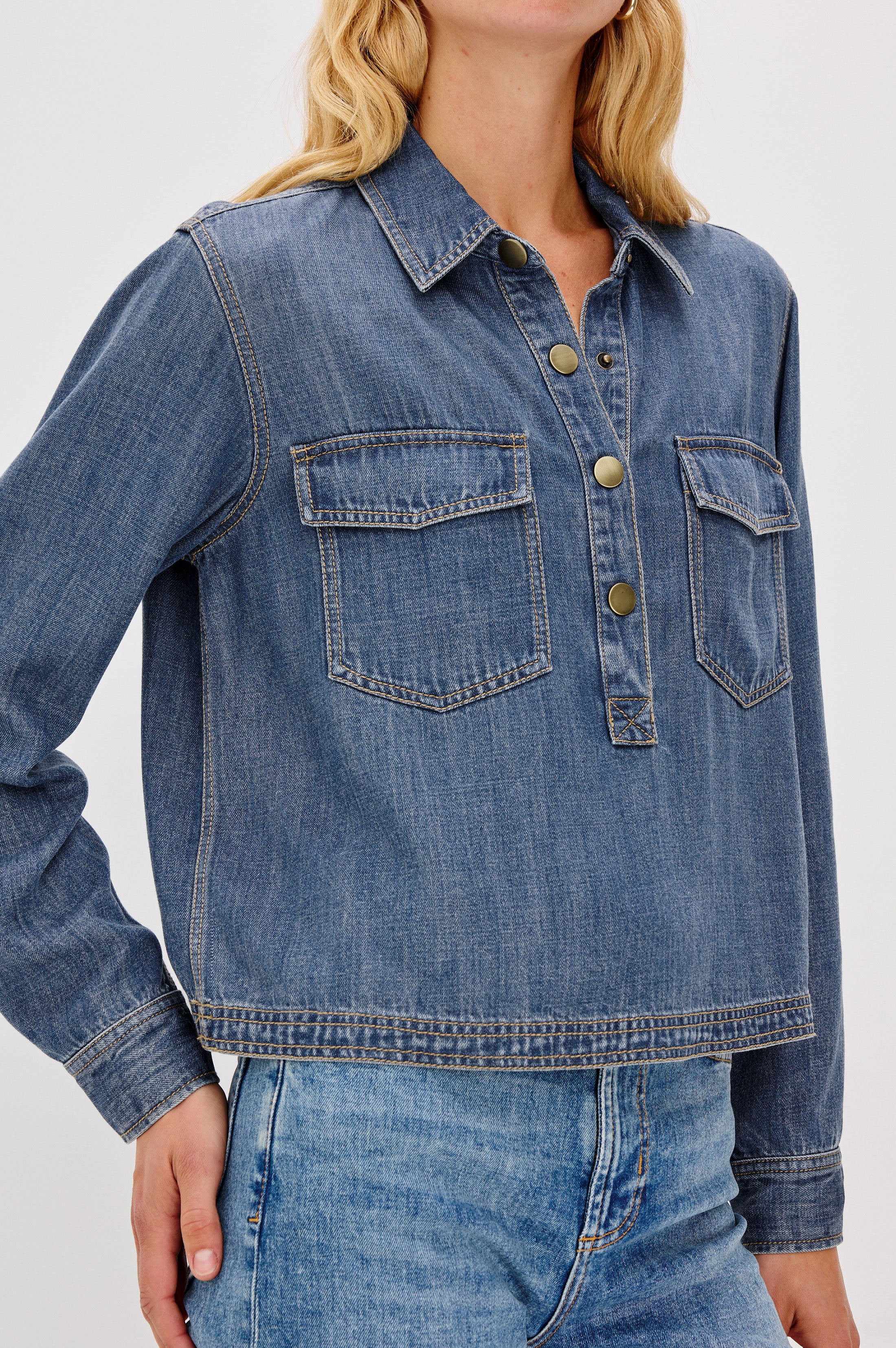 Close up of a relaxed blue denim long sleeve shirt