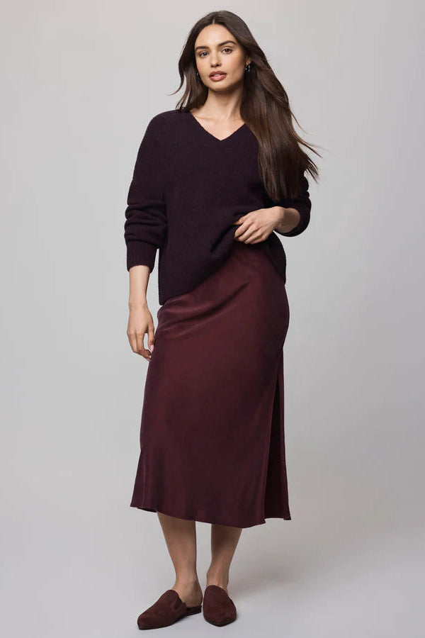 Woman wearing a dark purple dress with a plain background
