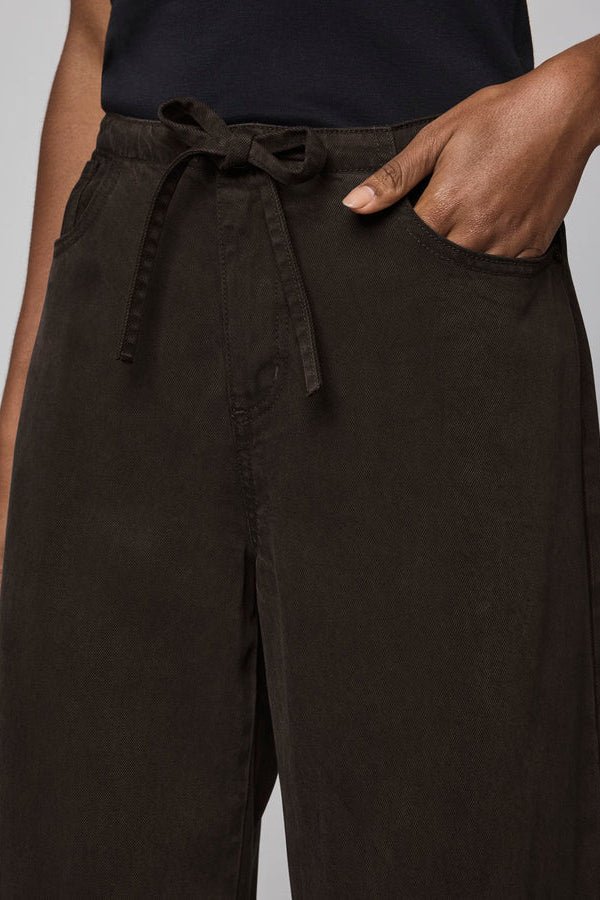 Dark brown wide-leg pants with a tie waist on a neutral background