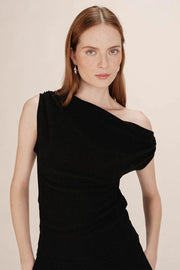 Woman wearing a black one-shoulder top