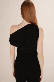 Woman wearing a black one-shoulder top