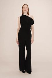 Woman wearing a black one-shoulder top and black pants