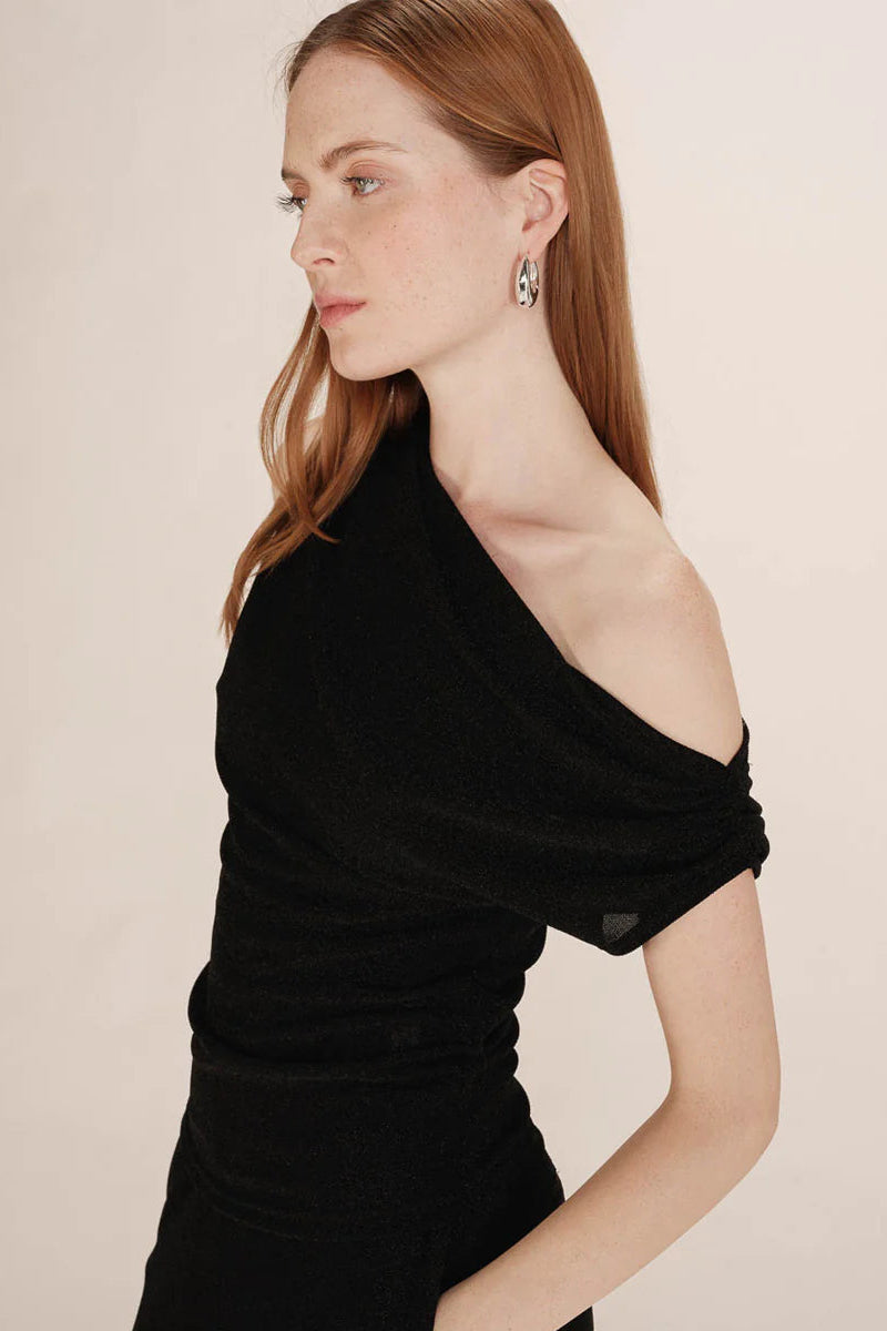 Woman wearing a black one-shoulder top
