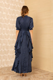 Black view of woman wearing a silk v-neck navy blue dress with ruffles
