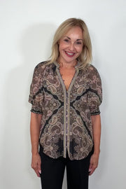 Video of a woman wearing a cotton and silk blend black half sleeve top with a light brown pattern turning around to show the back