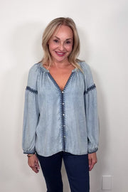 Video of a woman wearing a blue tencel blouse with stitch detailing