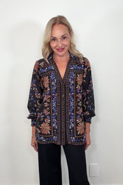 Video of woman wearing a v-neck black silk printed long sleeve blouse