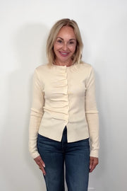 Video of a woman wearing a rouched in the buttons cream long sleeve knitted top
