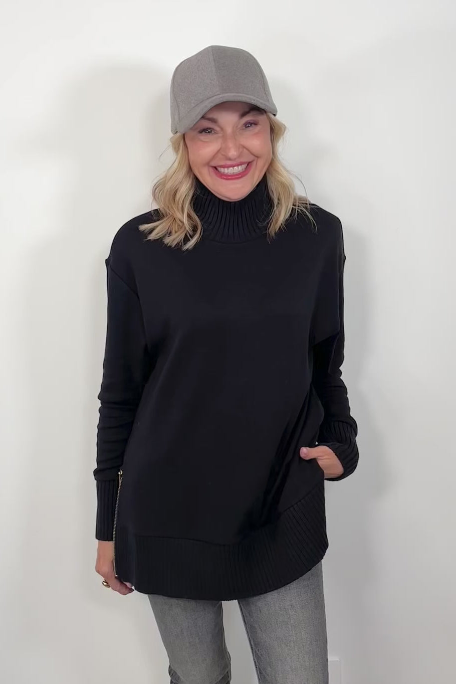 video if a woman wearing a black mock neck sweatshirt