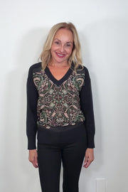 Video of woman wearing a v-neck black long sleeve fitted sweater