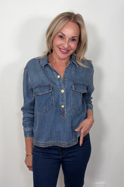 Video of a woman wearing a relaxed blue denim long sleeve shirt