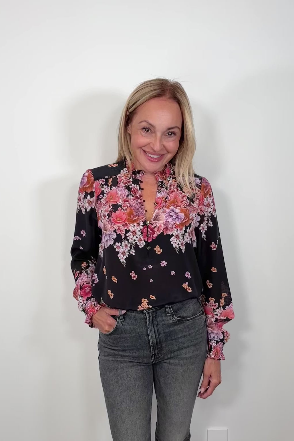 Video of woman wearing a black long cuffed sleeve silk blouse tucked in