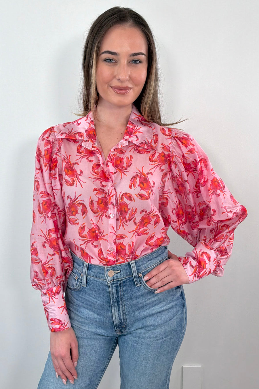 Woman wearing pink blouse with crab, print all over
