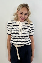 Woman wearing a black and white striped knitted short sleeve Henley tee