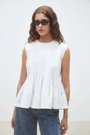 Woman wearing a white sleeveless top, front