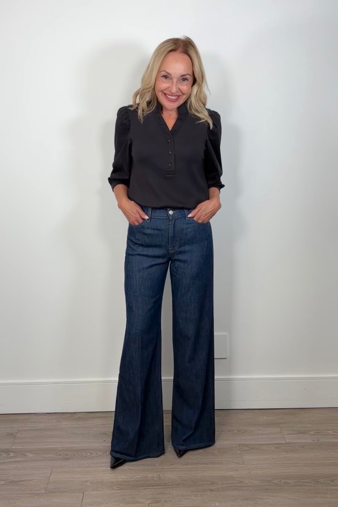 woman wearing a black half sleeve top with wide leg blue jeans