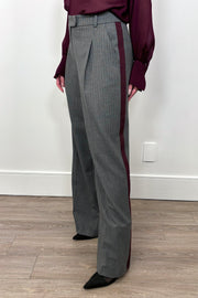 3/4 view of woman wearing a gray pinstripe wide leg pant with a burgundy line down the leg