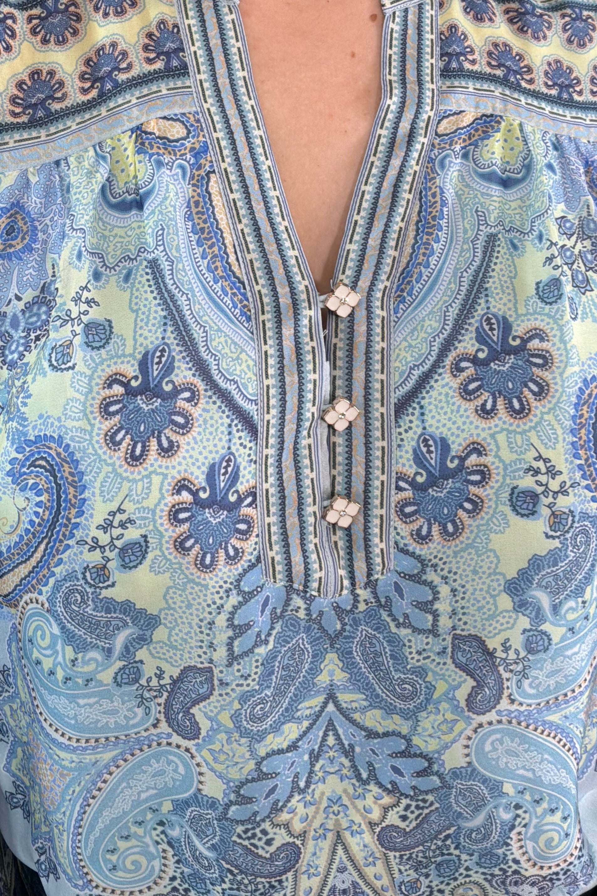 Close-up of a blue paisley patterned silk ruffle blouse