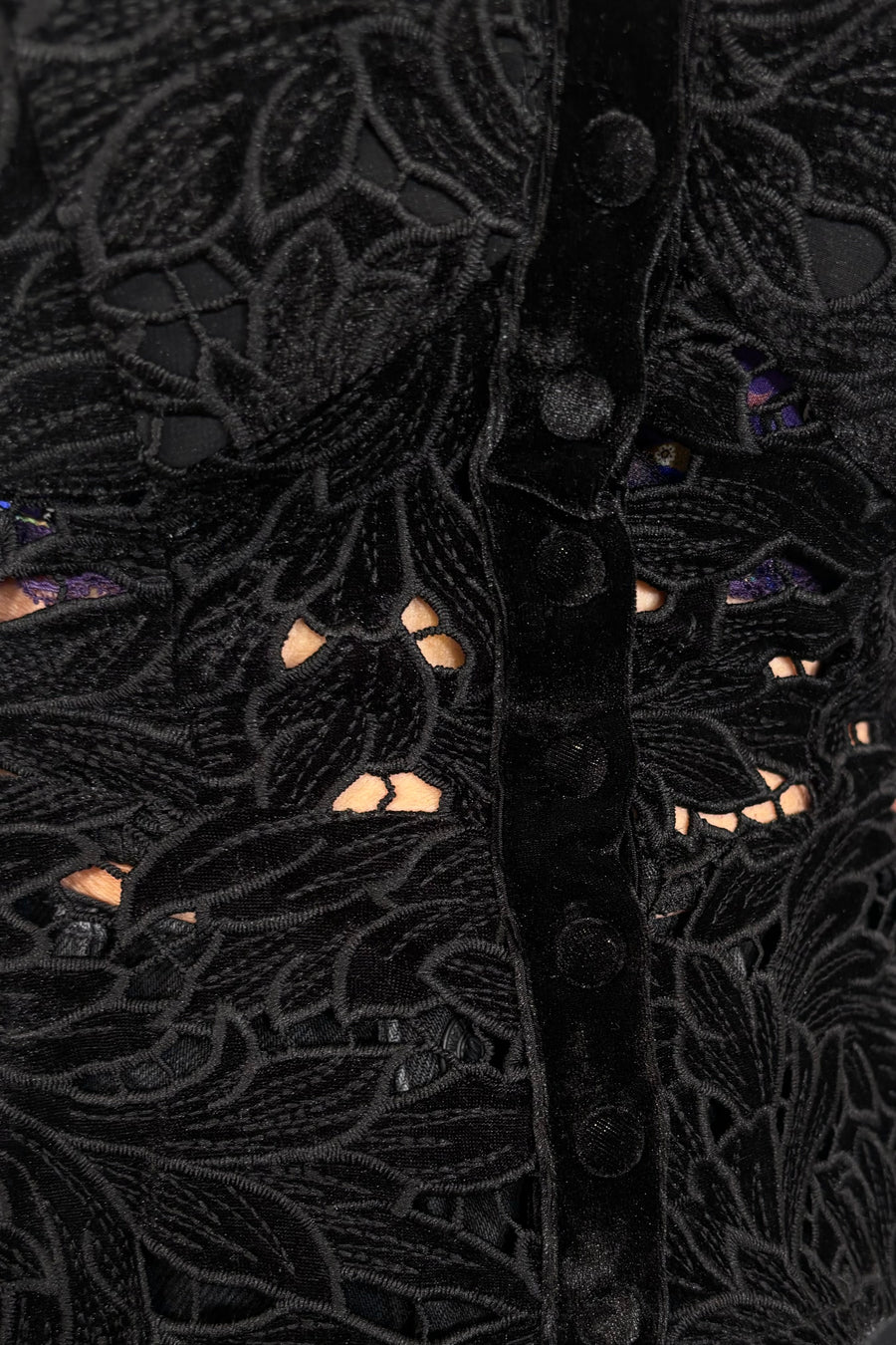 Close-up of a black embroidered garment with intricate patterns