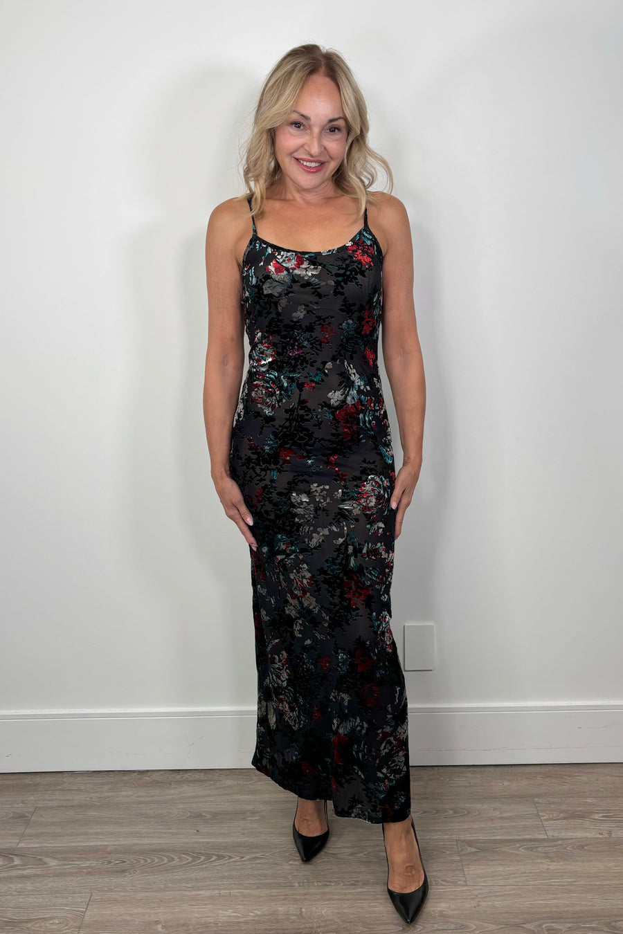 Woman wearing a floral maxi fitted dress with velvet detailing