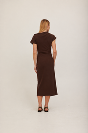 A woman modeling a dark brown off-the-shoulder midi dress with a fitted waist and short sleeves. 