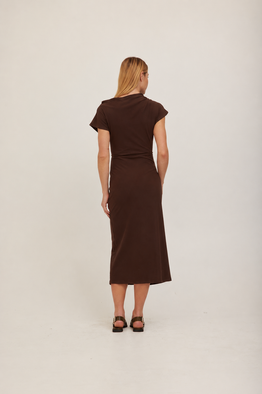 A woman modeling a dark brown off-the-shoulder midi dress with a fitted waist and short sleeves. 