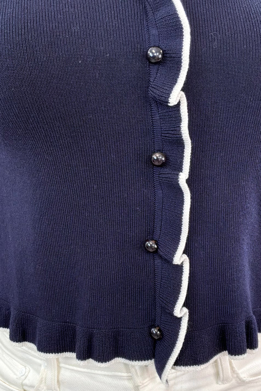 Close up of Woman wearing button up cropped top with collar with white details