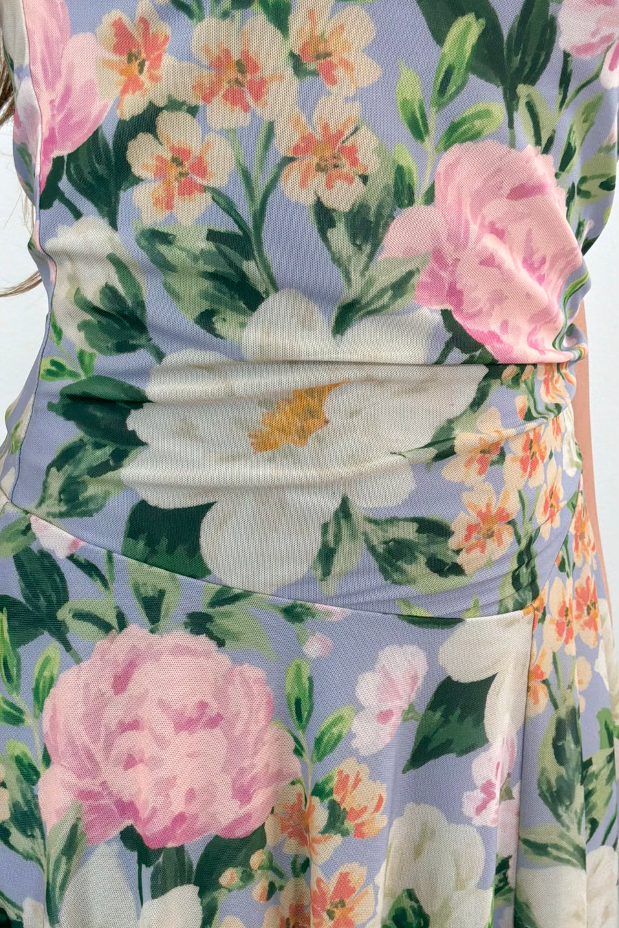 Close up of a woman wearing a floral print sleeveless midi asymmetrical dress 