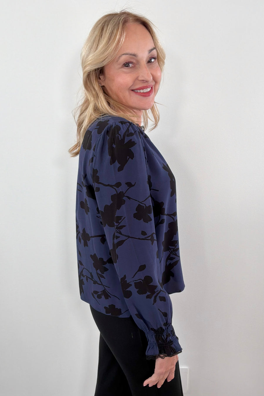 woman wearing a blue floral blouse with lace trim