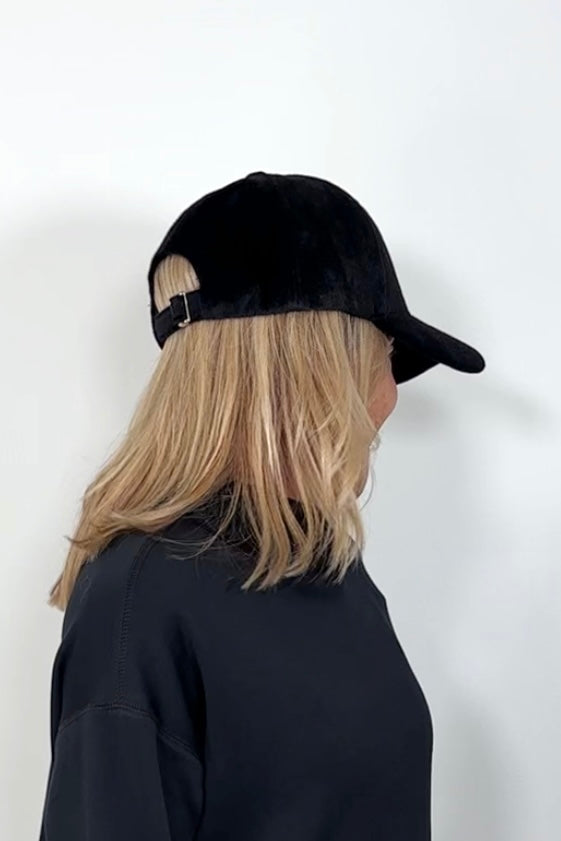 side view of a woman wearing an black coloured baseball felt hat