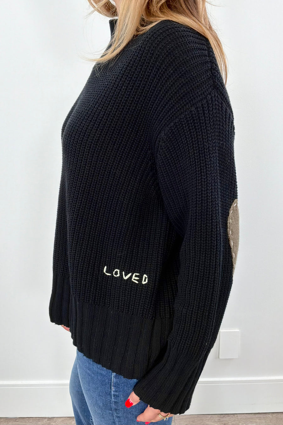 Woman wearing a black sweater with green heart patches