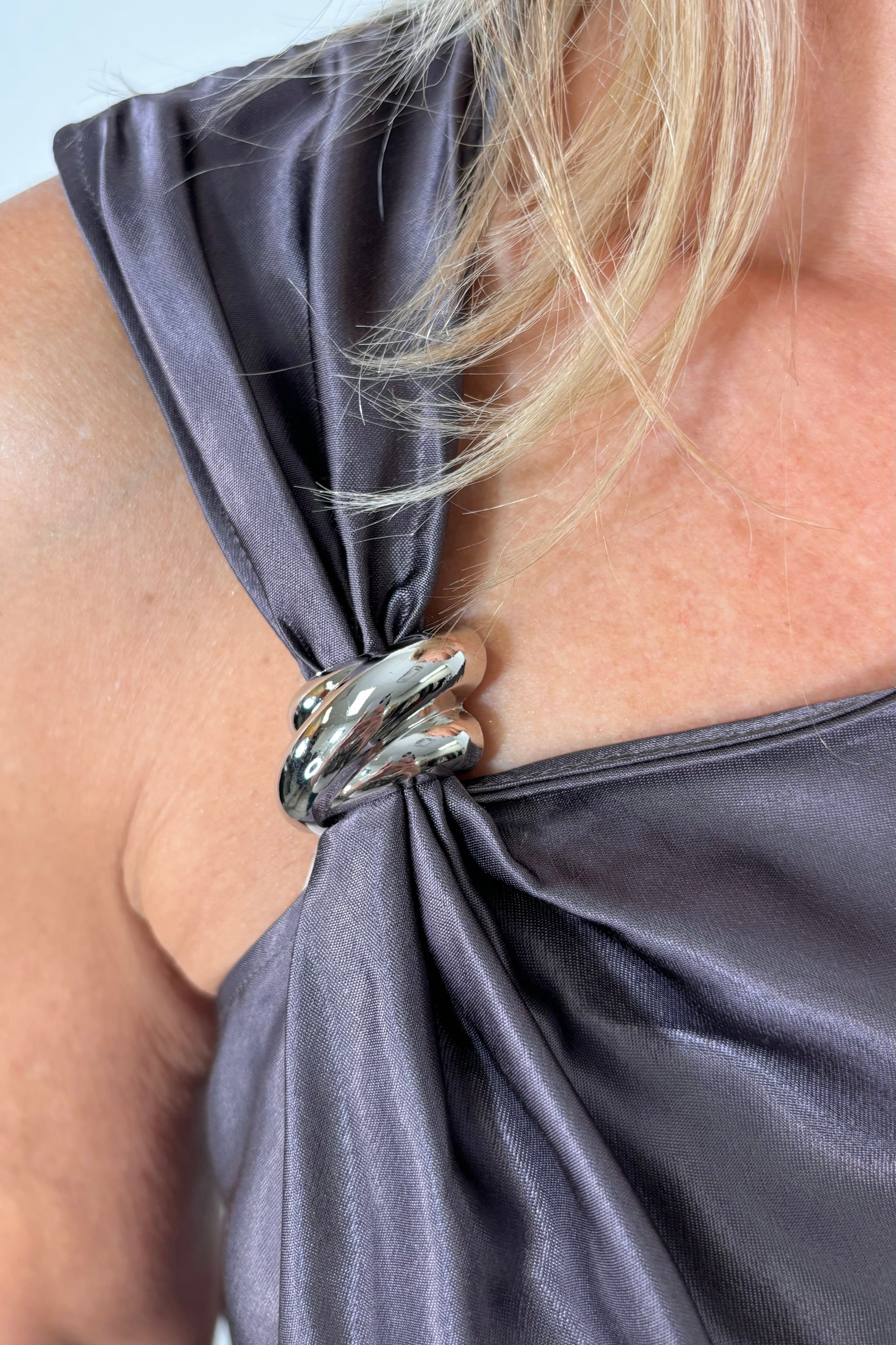 Close up of the metal detailing on a deep metallic gray tank top 