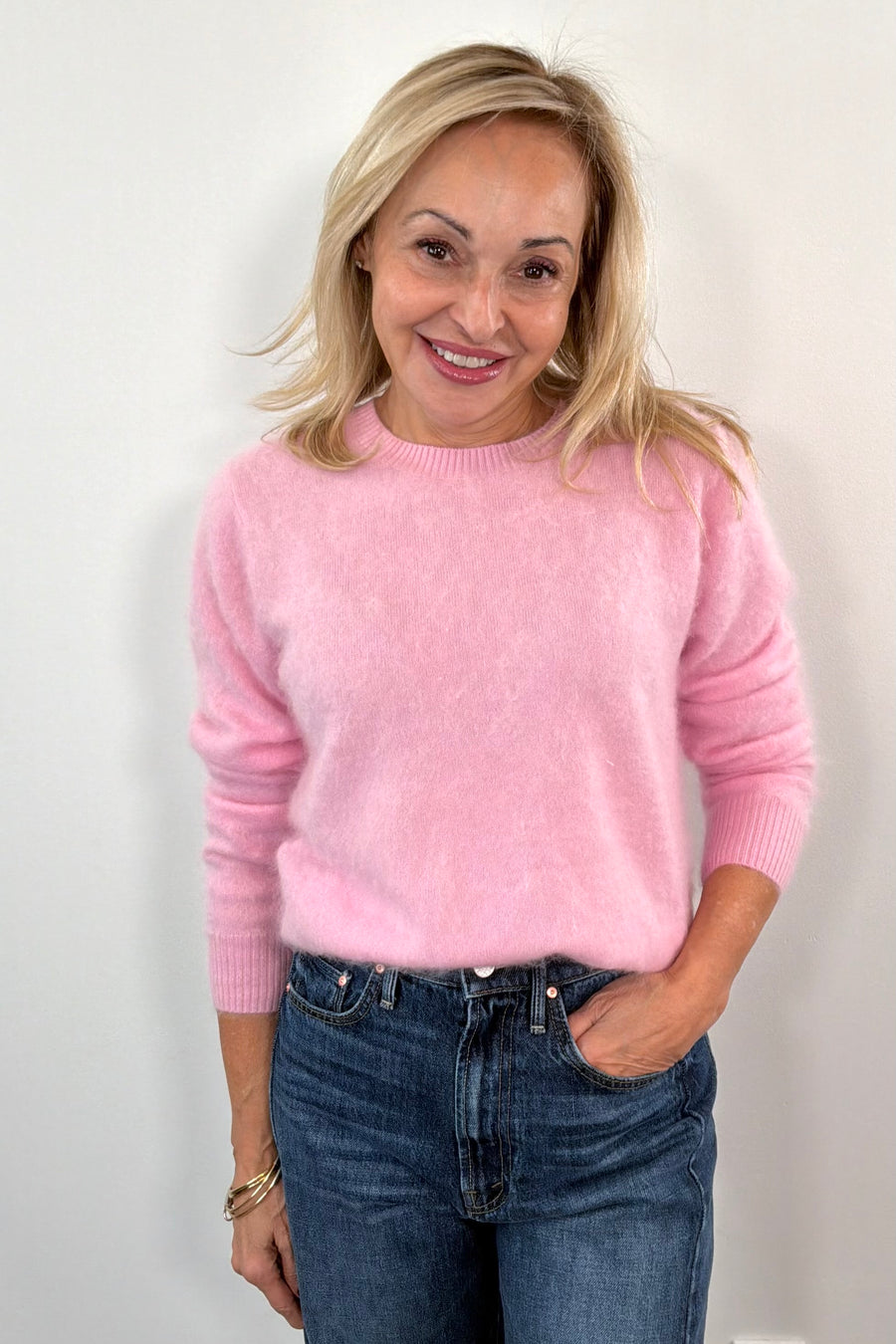 Woman wearing a pink sweater and blue jeans 